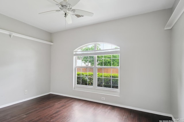spare room featuring baseboards, a ceiling fan, dark wood-style floors, and visible vents