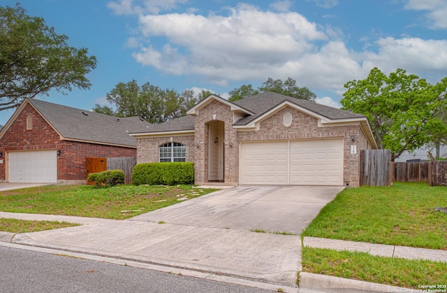 ranch-style home with brick siding, driveway, fence, and a front yard