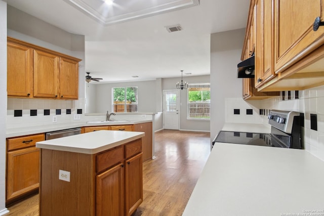 kitchen with decorative backsplash, a peninsula, range with electric stovetop, light countertops, and a sink
