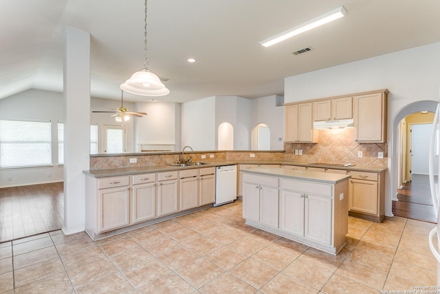 kitchen featuring decorative backsplash, visible vents, arched walkways, dishwasher, and a sink