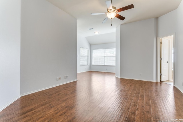 spare room with baseboards, ceiling fan, vaulted ceiling, and dark wood-style floors