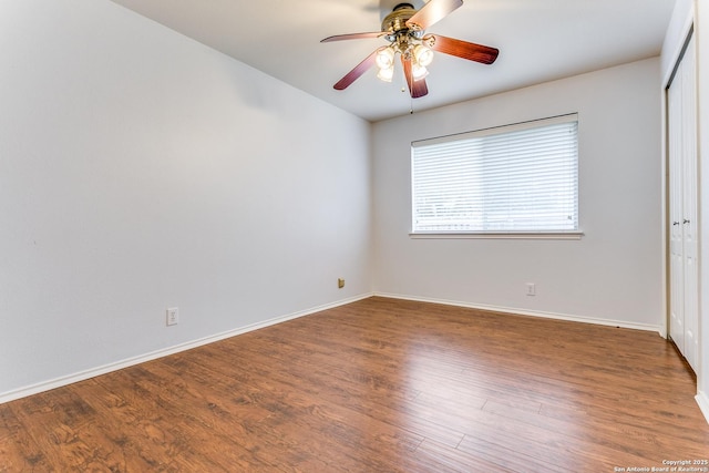 unfurnished bedroom featuring a ceiling fan, baseboards, wood finished floors, and a closet