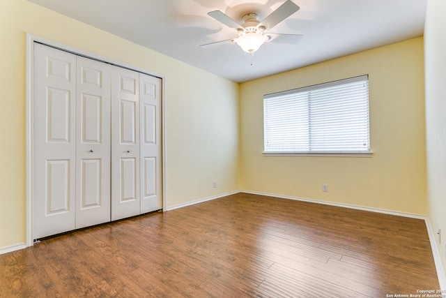 unfurnished bedroom with baseboards, ceiling fan, a closet, and wood finished floors