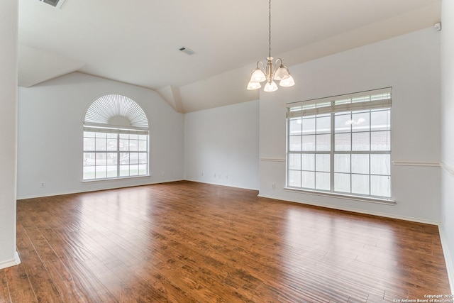 unfurnished room with visible vents, vaulted ceiling, wood finished floors, baseboards, and a notable chandelier
