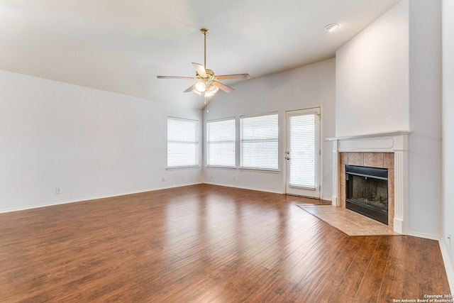 unfurnished living room featuring wood finished floors, a fireplace, baseboards, ceiling fan, and vaulted ceiling