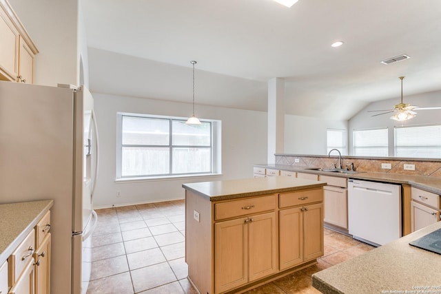 kitchen with a sink, light brown cabinetry, and white appliances