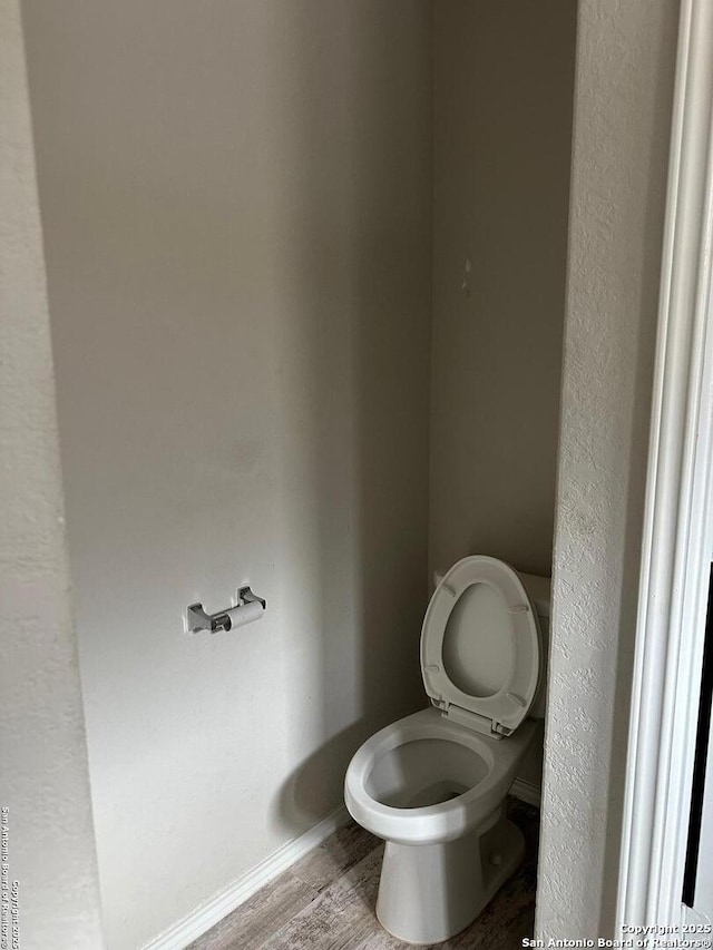 bathroom featuring wood finished floors and toilet