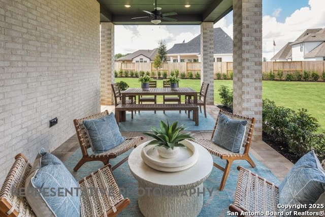 view of patio with fence, outdoor dining area, and ceiling fan