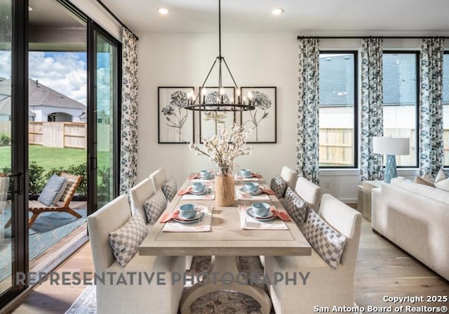 dining space featuring recessed lighting, wood finished floors, and a notable chandelier