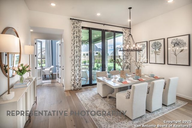 dining room with baseboards, a chandelier, french doors, and wood finished floors