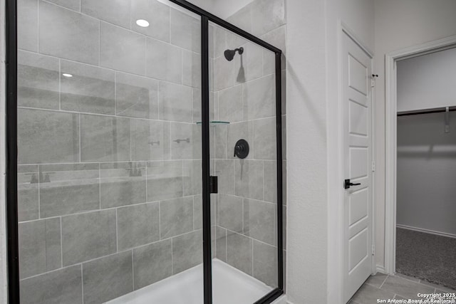 full bathroom featuring a walk in closet and a shower stall