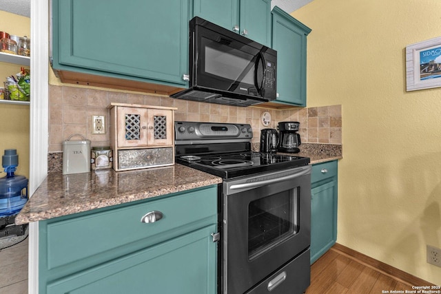 kitchen featuring backsplash, electric range, black microwave, wood finished floors, and baseboards