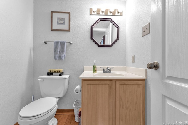 bathroom featuring toilet, wood finished floors, and vanity