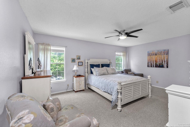 bedroom featuring visible vents, carpet flooring, a textured ceiling, and baseboards