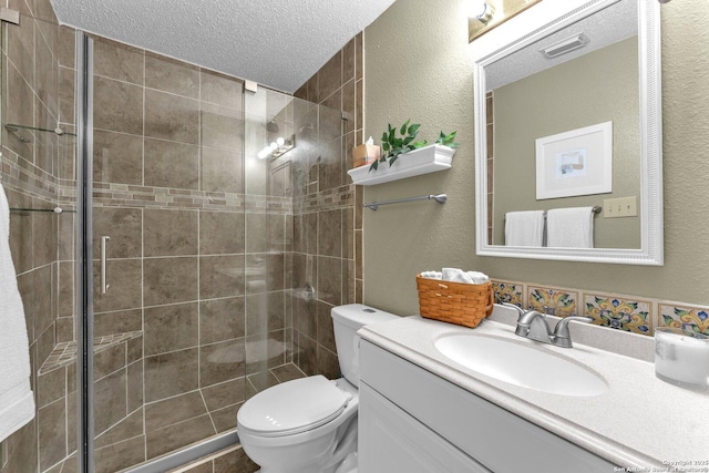 bathroom featuring vanity, a textured ceiling, toilet, and a shower stall