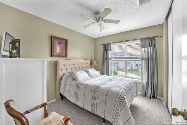 bedroom featuring visible vents, carpet flooring, baseboards, and a textured ceiling