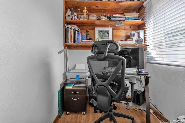 office featuring baseboards, a textured wall, and wood finished floors