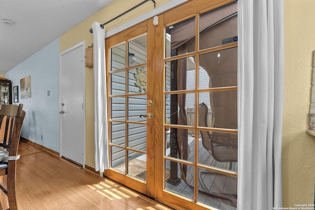 entryway with baseboards, french doors, and wood finished floors