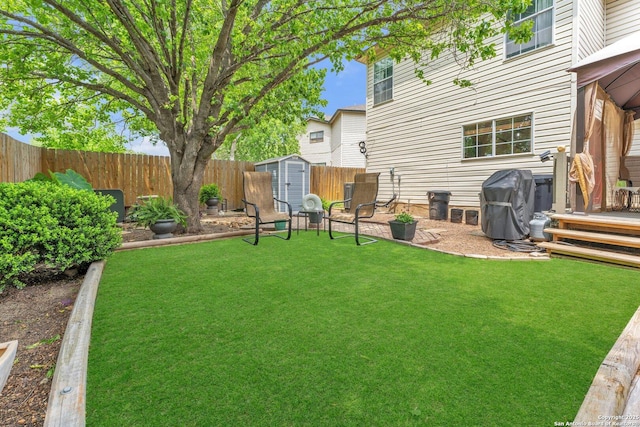 view of yard featuring a storage shed, an outdoor structure, and a fenced backyard