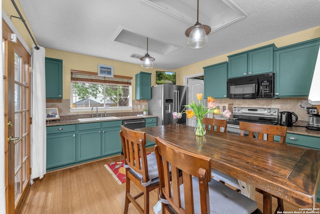 kitchen featuring a sink, a textured ceiling, backsplash, and stainless steel appliances