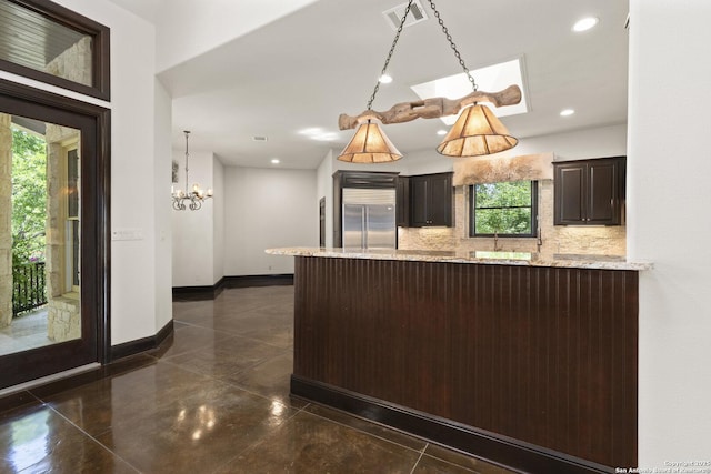 kitchen with visible vents, backsplash, a healthy amount of sunlight, and stainless steel built in refrigerator