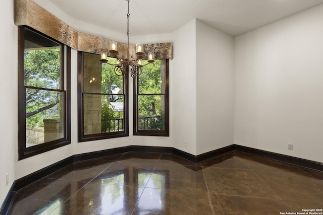 unfurnished dining area with an inviting chandelier, baseboards, and granite finish floor