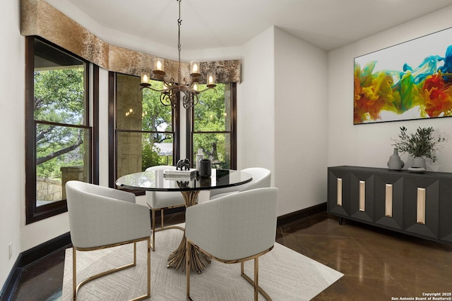 dining space with concrete flooring, baseboards, and a chandelier