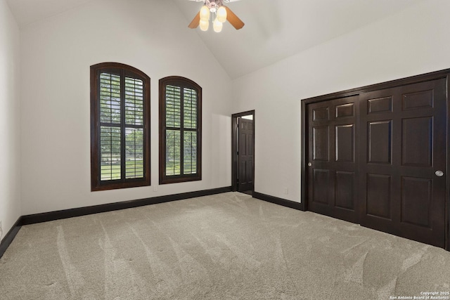unfurnished bedroom with carpet floors, a ceiling fan, baseboards, and high vaulted ceiling