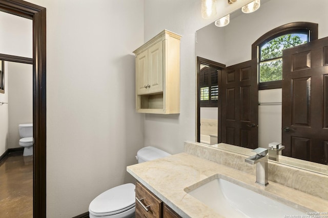bathroom with vanity, baseboards, and toilet