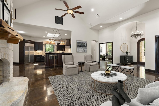 living area with arched walkways, high vaulted ceiling, and plenty of natural light