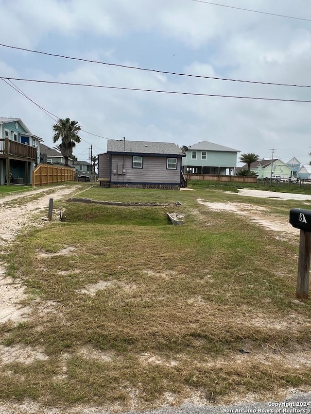 view of front of home featuring dirt driveway and fence