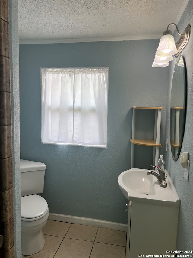 bathroom featuring crown molding, tile patterned flooring, vanity, toilet, and a textured ceiling