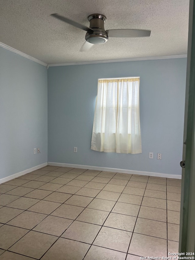 empty room with a ceiling fan, a textured ceiling, ornamental molding, and baseboards