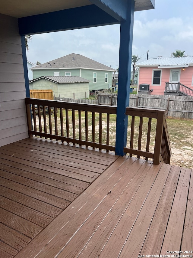wooden terrace with a fenced backyard and a lawn