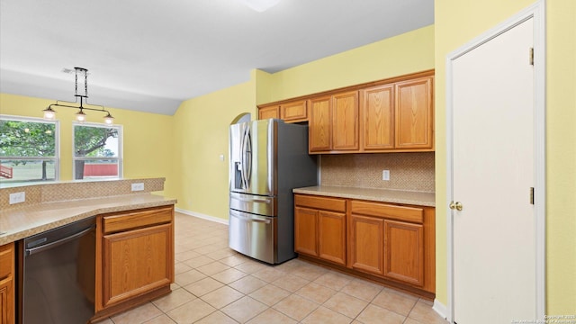 kitchen featuring light countertops, appliances with stainless steel finishes, decorative backsplash, and brown cabinetry