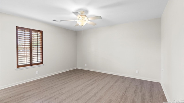 unfurnished room featuring visible vents, a ceiling fan, baseboards, and wood finished floors
