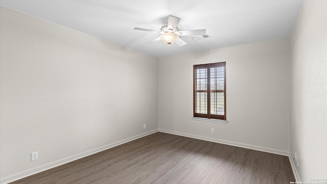 empty room featuring baseboards, a ceiling fan, dark wood-type flooring, and visible vents