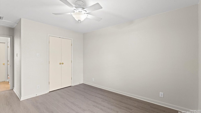 unfurnished bedroom with baseboards, a closet, and wood finished floors