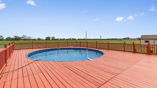 view of pool featuring a fenced in pool, a wooden deck, and a rural view