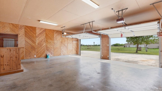 garage featuring wood walls and a garage door opener