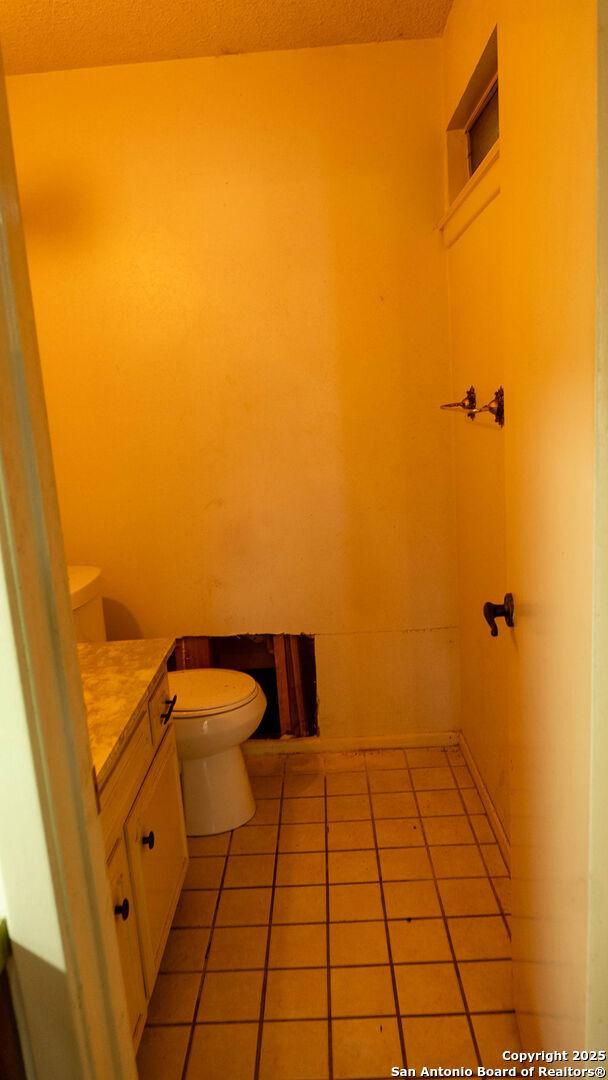 bathroom featuring toilet, tile patterned flooring, and vanity