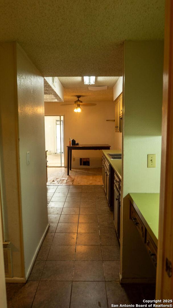 kitchen featuring light countertops, dark tile patterned floors, and a ceiling fan