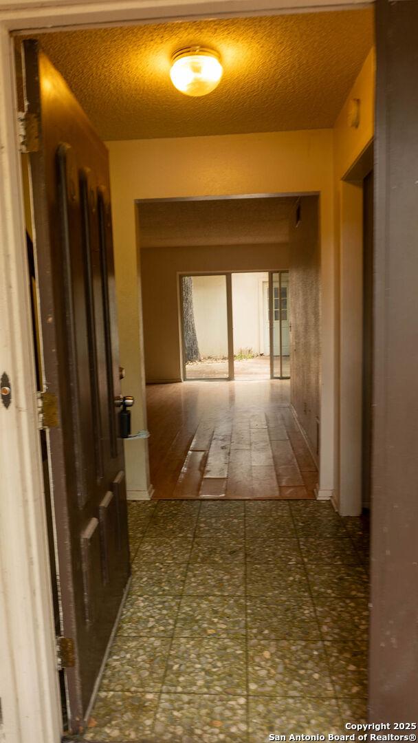 hallway featuring a textured ceiling and tile patterned floors