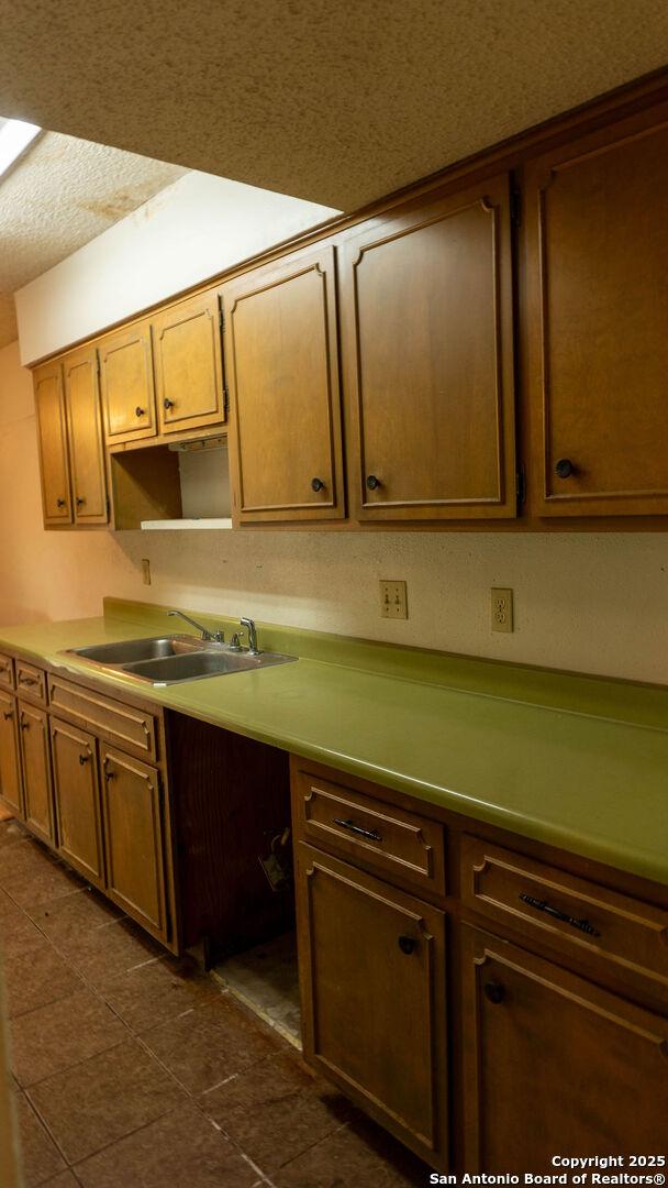kitchen featuring a sink and dark tile patterned flooring