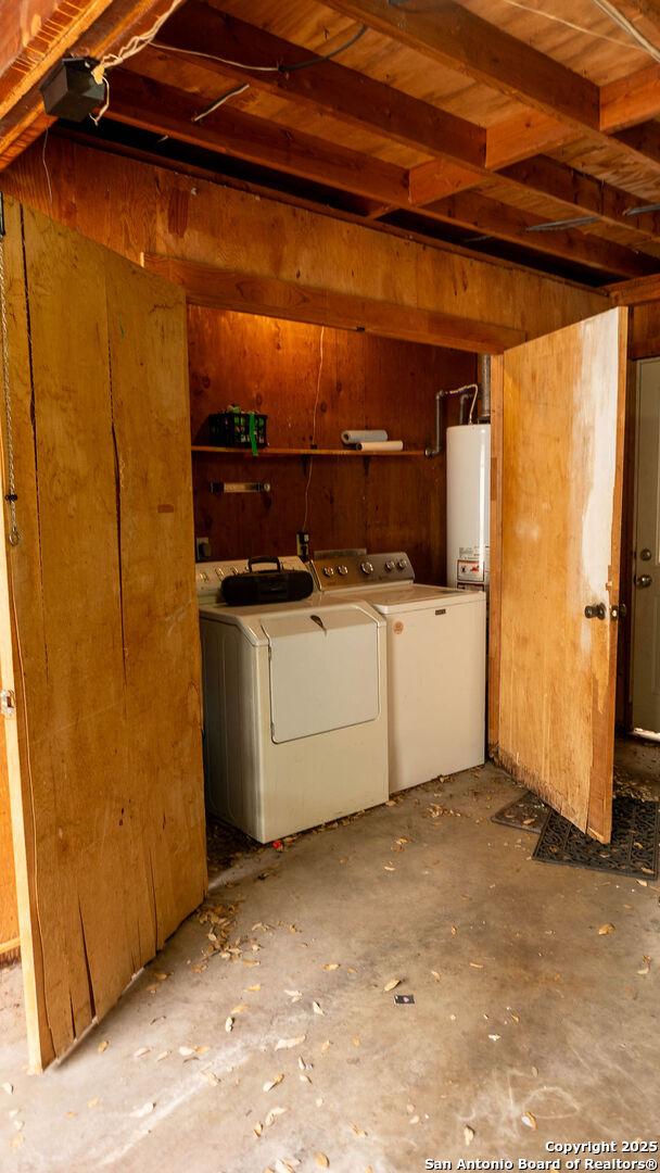below grade area featuring water heater and separate washer and dryer