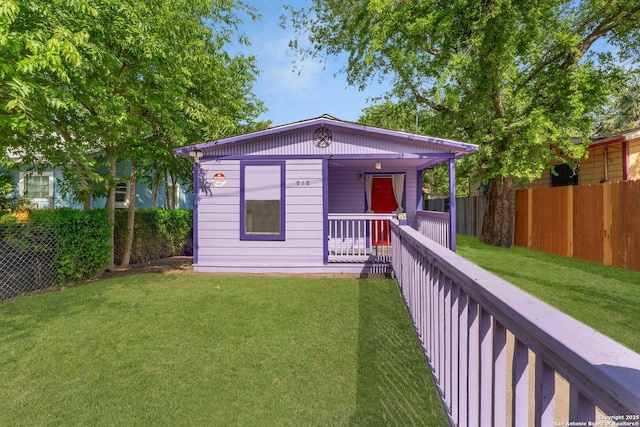 view of front of property featuring a porch, a front lawn, and fence