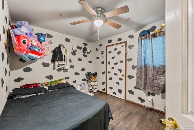 bedroom with wallpapered walls, ceiling fan, and wood finished floors
