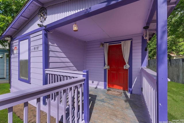 entrance to property featuring fence and a wooden deck