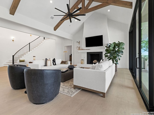living room with light wood-style floors, high vaulted ceiling, a ceiling fan, beamed ceiling, and stairway