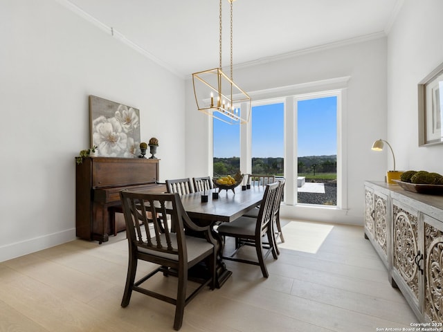 dining room featuring crown molding, baseboards, and a notable chandelier